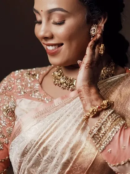 A close-up capturing the bride's happy expression and the beautiful texture of the embroidery on her blouse.