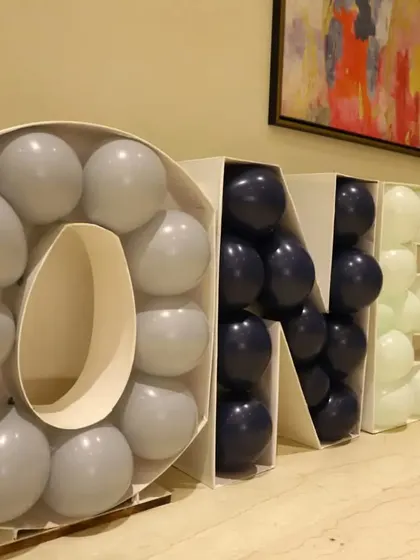 A custom "ONE" balloon mosaic structure. This is a popular and eye-catching decor piece for first birthday parties that can be customized with any balloon colors.