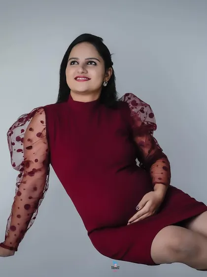 A modern and chic studio look. This couple chose matching burgundy outfits for a stylish and contemporary maternity portrait series.