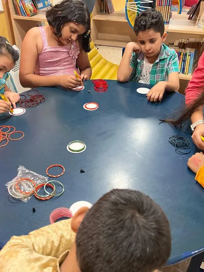 The kids are deeply focused on making their own diya holders. This hands-on activity helps them connect with the traditions of Diwali.