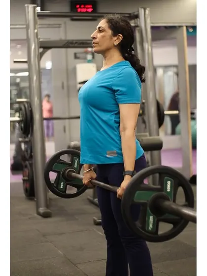 The deadlift is a full-body strength builder. This client maintains a straight back and proper form, which is crucial for safety and effectiveness.