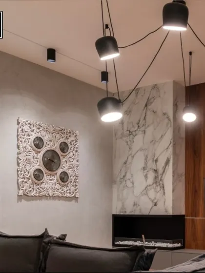 This living room features a dramatic, spider-like pendant fixture that spreads light across the ceiling. It's a bold choice that ensures your happy place is always well-lit and stylish.