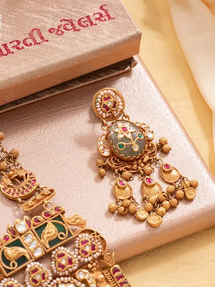 A closer look at the earrings accompanying our Maharani Haar. They perfectly mirror the central pendant's Bikaneri enamel work and gemstone setting, designed to complete the look of regal sophistication.