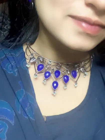 A closer look at this blue choker set, featuring a delicate black polish chain and deep blue stones. It's a versatile piece that can be dressed up or down.