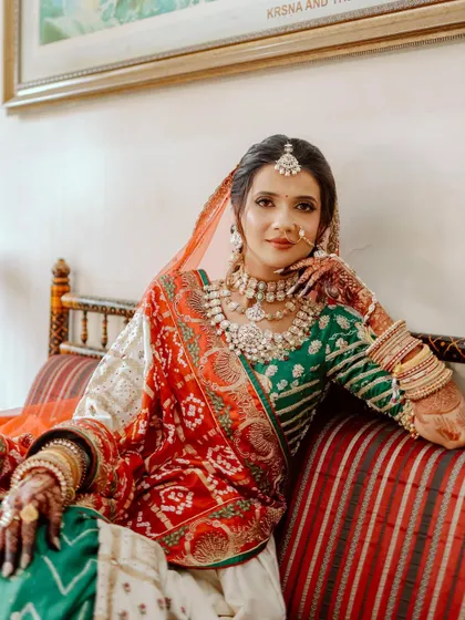 The bride seated in a traditional setting, looking regal and poised in her full bridal attire.