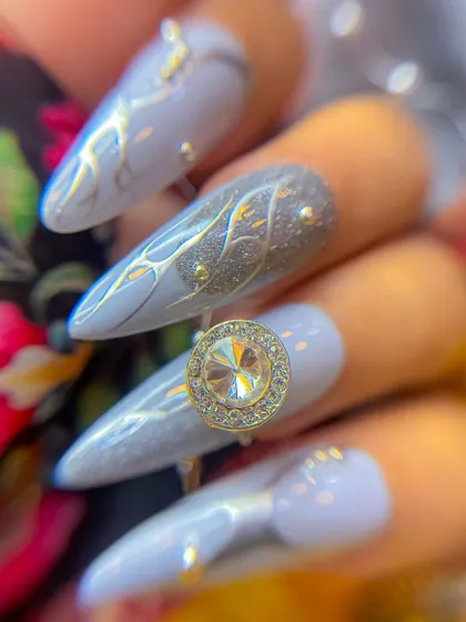 A detailed macro shot of the Navratri nail art, focusing on the texture of the glitter nail and the intricate silver line work.
