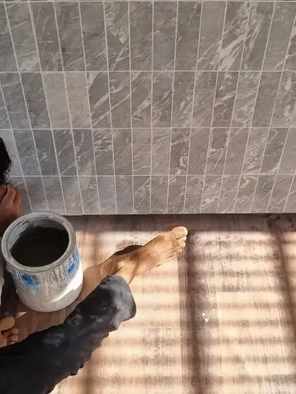 The process of grouting the marble tiles on the custom bar. This image captures the hands-on work and precision that goes into creating the refined textures in our bespoke furniture pieces.