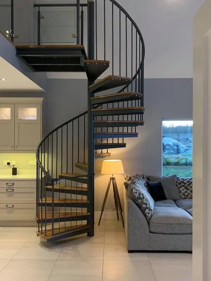 The finished spiral staircase in its home. The dark grey steel and warm oak treads provide a nice contrast with the room's neutral colors.