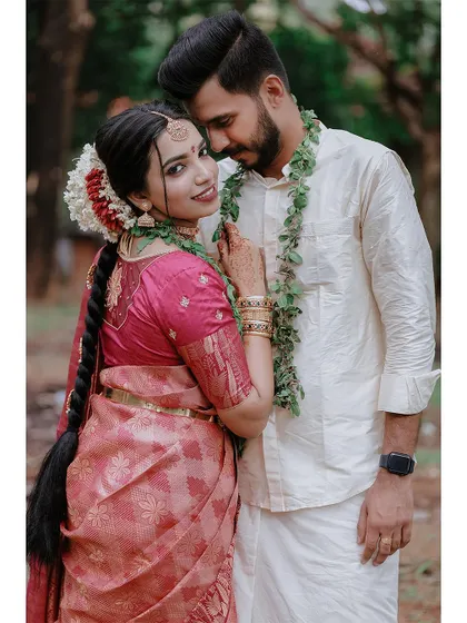 A beautiful portrait of a couple in their wedding attire, the bride's long braid and flowers adding to the traditional charm.
