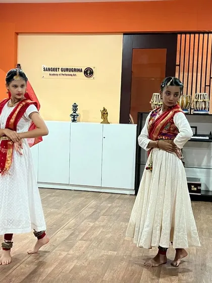 Two students performing a Kathak duet, showcasing their synchronization and individual artistry.