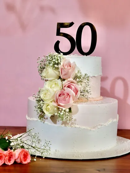 Celebrating 50 golden years with this elegant two-tiered floral cake. Adorned with fresh roses, it’s a timeless design for a truly special milestone anniversary.