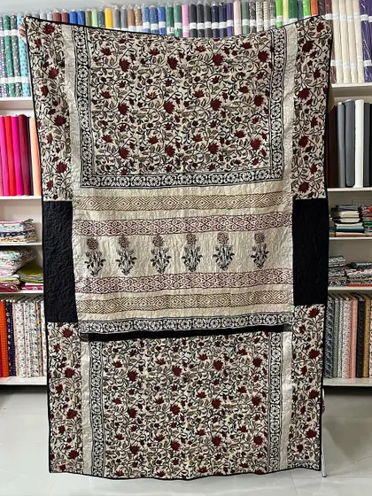 A stunning example of how we combine different parts of a single saree to create a cohesive design. This memory quilt uses the floral body and patterned borders to create a beautiful, paneled effect.
