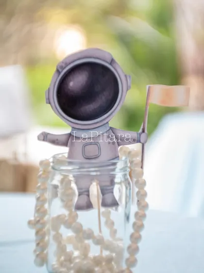 A charming and simple table centerpiece featuring a miniature astronaut cutout, adding a touch of the space theme to every table.