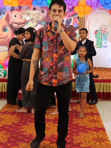 On the mic and ready to go at a Cocomelon themed birthday party. I adapt my hosting style and games to match any party theme you choose.