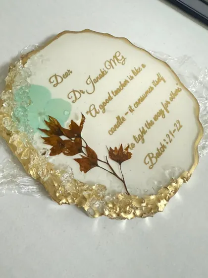 A close-up of one of the thank you coasters for the professors. You can see the delicate preserved flower and the beautiful gold script.
