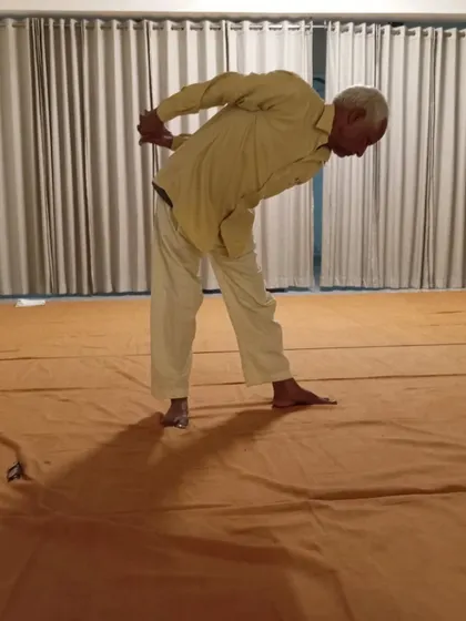 A standing posture that works on balance and spinal flexibility, practiced with grace.