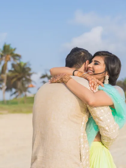 A playful and happy hug from behind, captured on a sunny beach. This photo perfectly encapsulates the fun and loving nature of the couple's relationship.