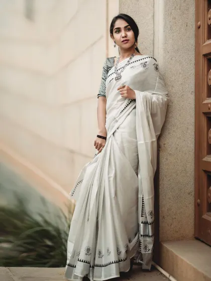 A three-quarter shot that provides a clear view of the saree's drape and the model's pose. The architectural details of the door frame the subject beautifully.