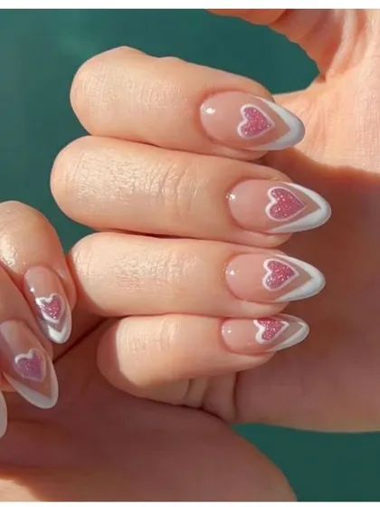 Wear your heart on your nails. This lovely design features a French manicure with a glittery pink heart outlined in white, creating a cute and romantic look.