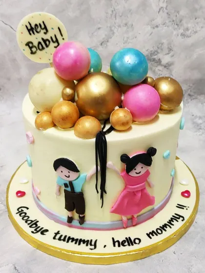 We celebrate the parents-to-be with this fun and charming "Goodbye Tummy, Hello Mommy" baby shower cake. Featuring cute figures of the couple and a cascade of colorful spheres, this cake is a joyful way to welcome the next chapter.