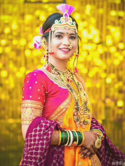 Another beautiful portrait of the bride against a festive yellow background, highlighting her bright smile and colorful attire.