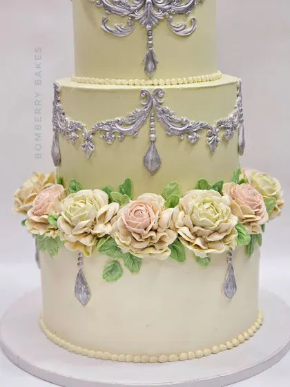 A close-up of the beautiful, hand-piped pastel buttercream roses on the vintage engagement cake.