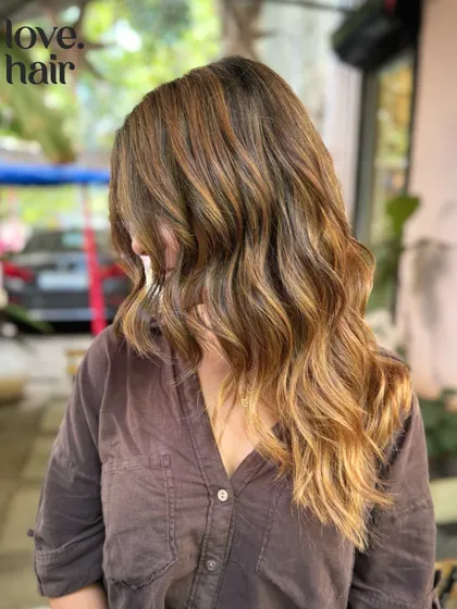 Molten lava hair. A fiery and warm bronde balayage with caramel and golden tones that look like flowing lava.