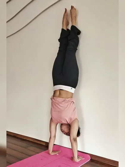 A wall-supported handstand helps to build shoulder strength and get comfortable being upside down.