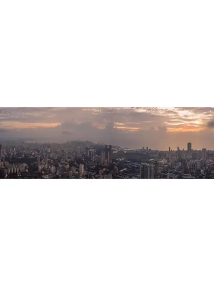 A wide panoramic shot of Mumbai, capturing the entire cityscape from a high vantage point under a cloudy sky.