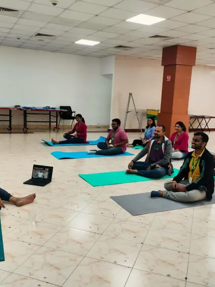 A wider shot of the hybrid corporate meditation session.
