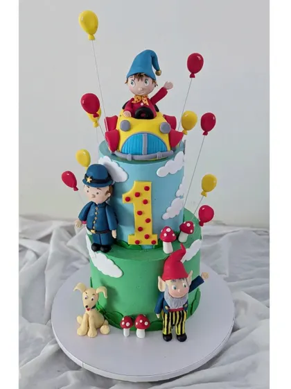 Another view of the two-tiered Noddy cake, complete with his car, friends, and tiny toadstools.