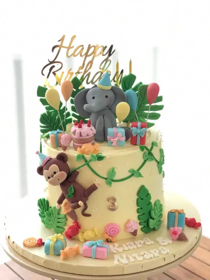 A brighter shot of the "sugar rush" jungle cake, highlighting the cute elephant and monkey toppers.