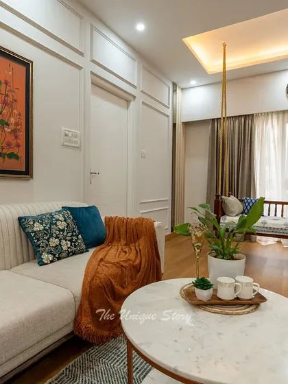 A detail shot of the living area, highlighting the traditional wooden swing set against floor-to-ceiling curtains. This element adds a classic Indian touch and a cozy corner for relaxation, perfectly complementing the modern sofa and decor.