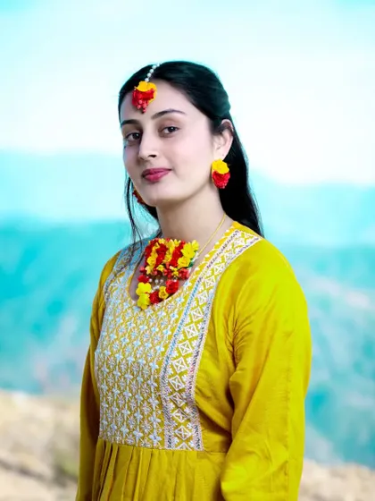 A beautiful portrait of the bride-to-be against the backdrop of the mountains, her yellow dress vibrant against the blue sky.