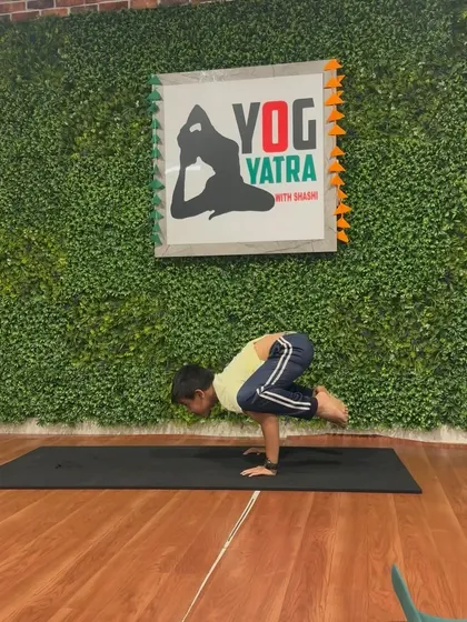 This young boy holds a steady Bakasana (Crow Pose), balancing his entire body weight on his hands with incredible focus.