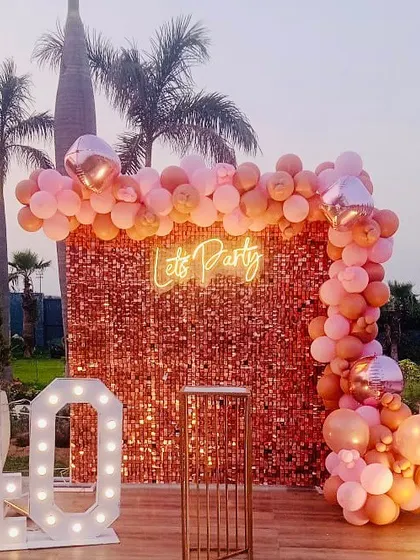 A chic 40th birthday party on an outdoor deck. The rose gold sequin wall and marquee numbers create a glamorous photo spot.