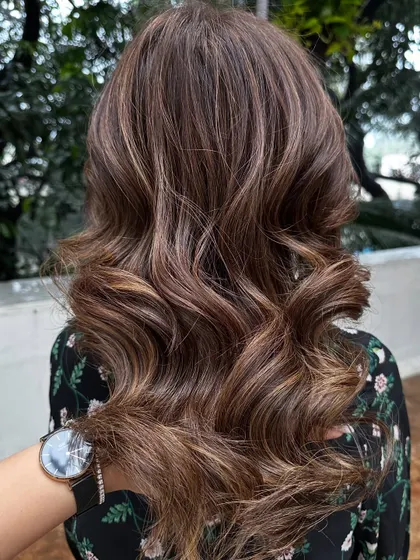Soft waves on medium-length hair with 'Caramello' highlights. The waves help to showcase the different tones in the color.