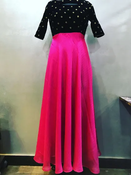 This is a custom two-piece dress. It has a black velvet top with gold polka dots and a flowing pink chiffon skirt.