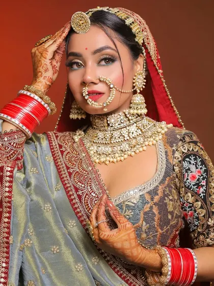 A full-on bridal pose that shows confidence and grace. The makeup ties together the entire look, from the maang tikka to the red bangles.