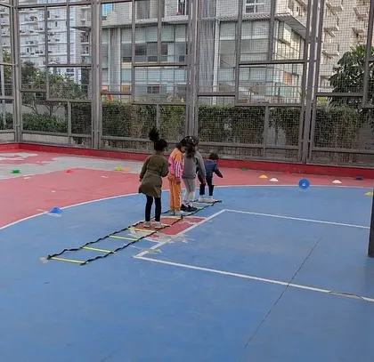 Our players use an agility ladder to improve their footwork and coordination on a basketball court. We adapt our drills to different surfaces, making sports accessible everywhere.