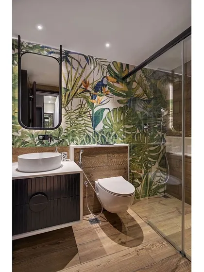 We used a vibrant tropical wallpaper as a feature in the son's bathroom, paired with wood-finish tiles to create a fun and immersive space.