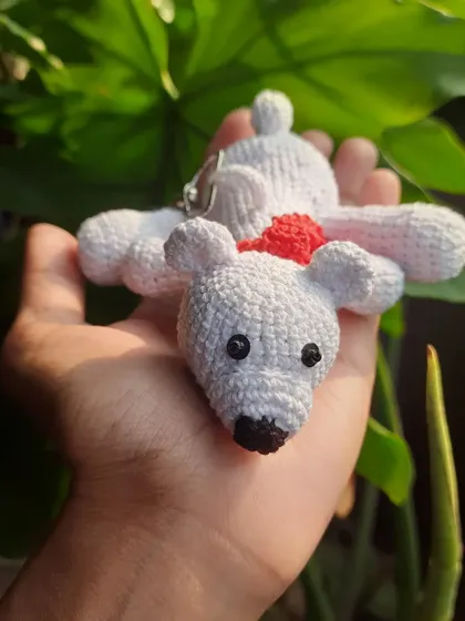 A front-facing view of the polar bear keychain with its scarf. The simple, sweet expression makes it an adorable companion.