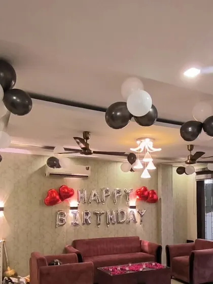 The living room area of the black and white themed decoration, with rose petals on the table for a romantic touch.