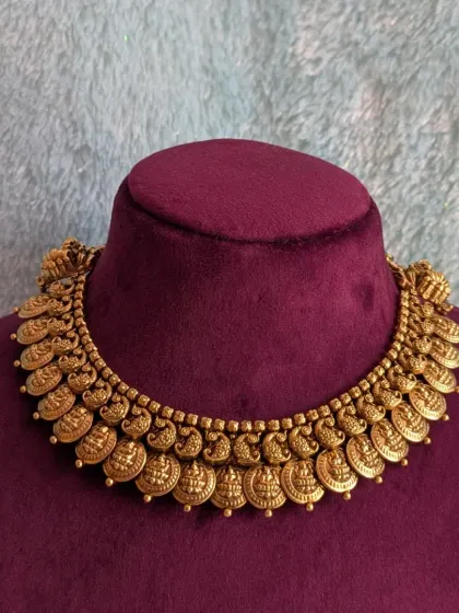 Displayed on a velvet bust, this Kaasu necklace shows how it sits beautifully on the neckline, creating a regal and traditional silhouette.