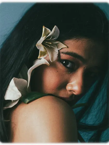 A creative composition where a flower is used to interact with the model's face, adding a surreal and beautiful touch.