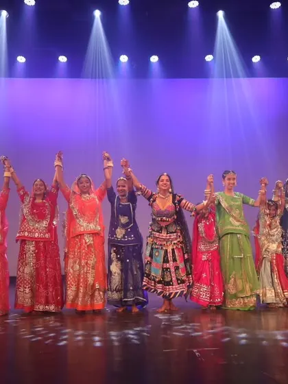 Taking a final bow on stage with a large group after a Rajasthani folk dance show. This demonstrates my experience with professional stage productions.