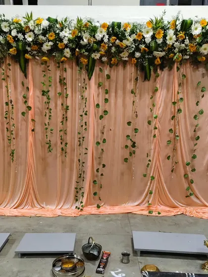 To celebrate a company milestone, I designed this elegant backdrop using soft fabric drapes, a fresh floral runner, and hanging green vines. It provides a perfect setting for photos and formal ceremonies.