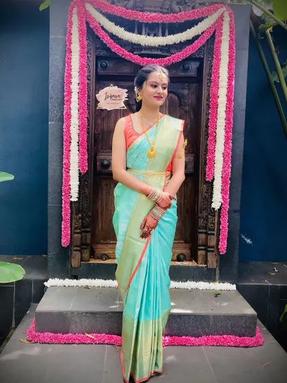 The sister of the bride posing by a traditionally decorated door. Her simple and elegant styling is perfect for the occasion.