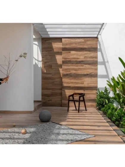 The terrace garden of the Hemadri penthouse, where a wooden feature wall and lush greenery create a private outdoor oasis in the city.