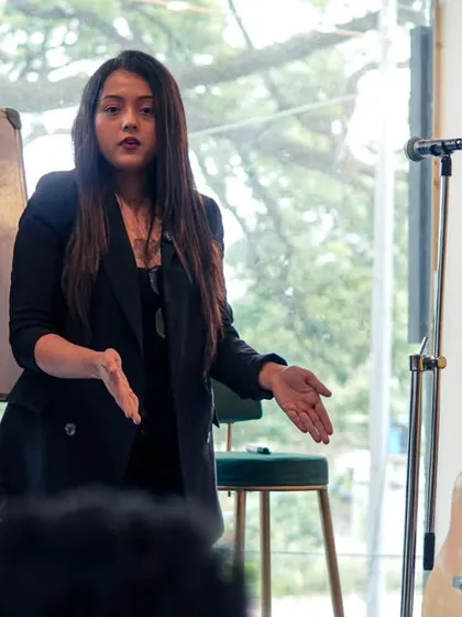 An instructor demonstrating vocal techniques in front of a whiteboard during a workshop.